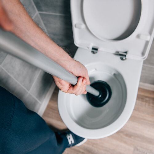 plumber plunging a toilet 