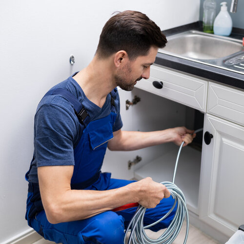 plumber providing drain cleaning